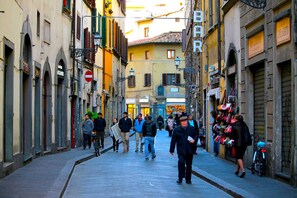 Una calle estrecha flanqueada por edificios, algunos con letreros que señalan tiendas o negocios.