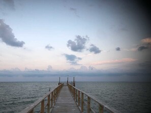 A wooden pier extending into calm waters with a clear sky above. - Hunt's Castle (Rockport)