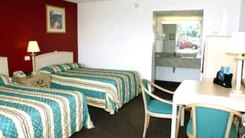 A hotel room with two beds, a desk, a chair, a lamp, a telephone, and a painting on the wall.