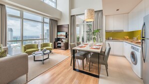 A modern apartment with a dining area, kitchen, and living room.