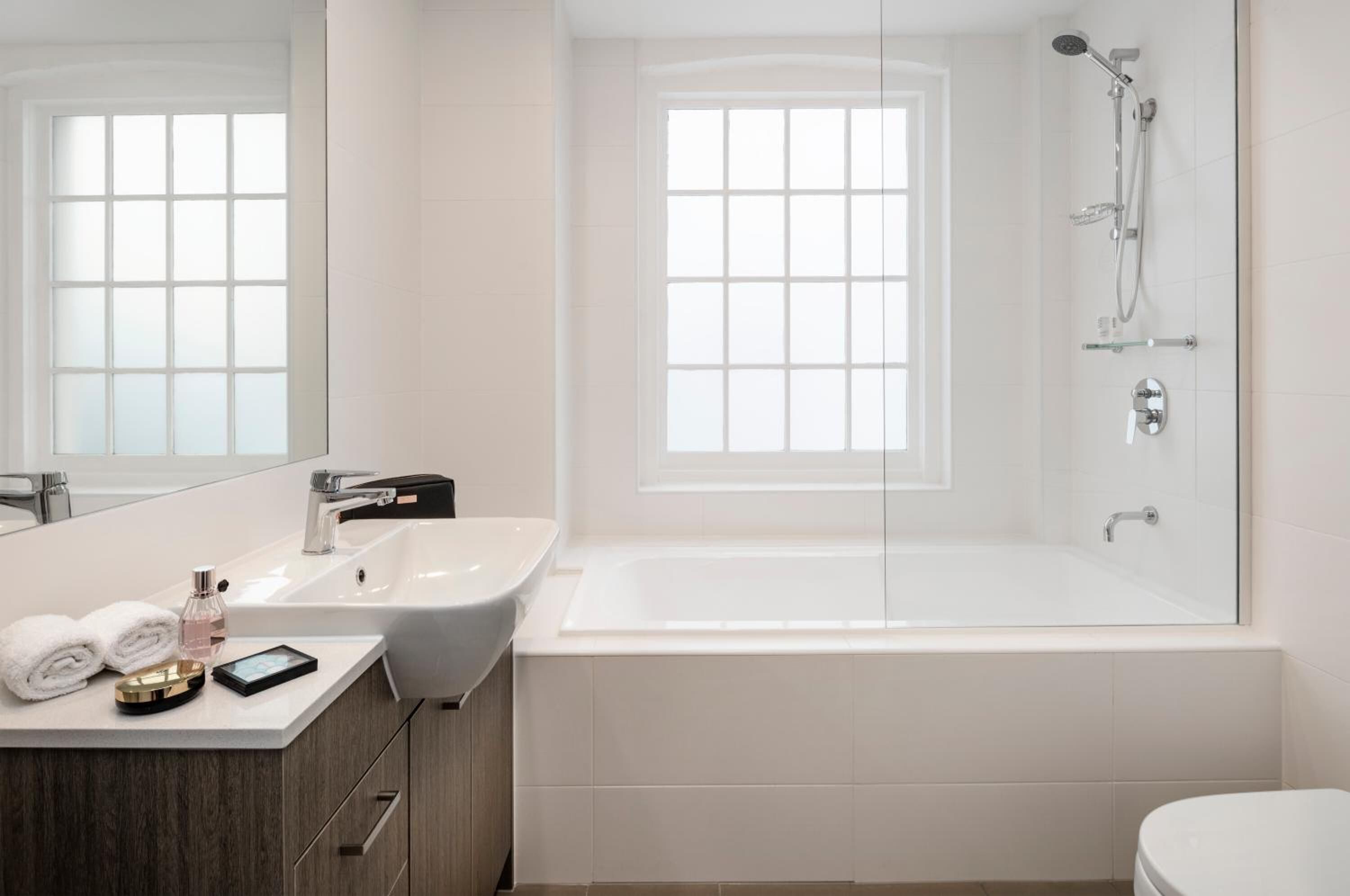 A modern bathroom with a large bathtub, a separate shower area, and a vanity with a sink and mirror.
