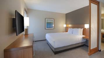 Une chambre d’hôtel avec un lit, une télévision, un bureau et une lampe.