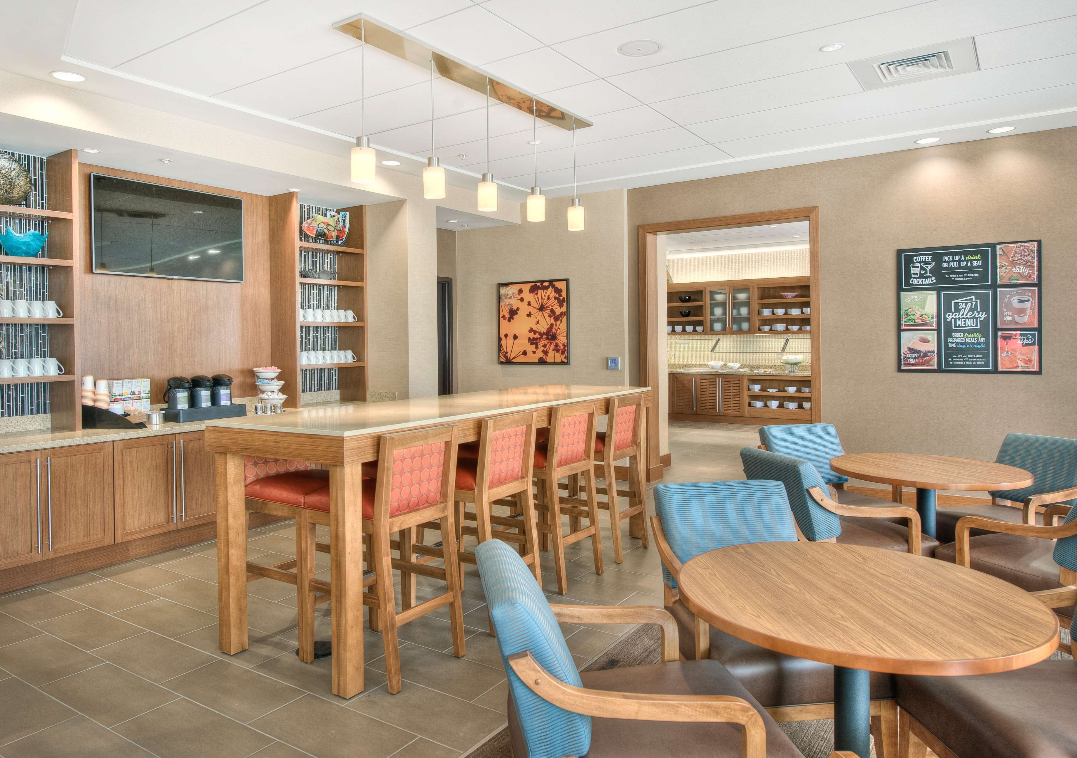 A modern cafe with wooden furniture, a bar area, and a menu board on the wall.