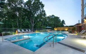 A swimming pool with lounge chairs and a wooden fence. - Hyatt Place Durham Southpoint (Durham)