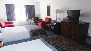 A hotel room with two beds, a desk with a chair, a television, and a dresser.