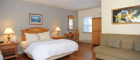 A bedroom with a bed, bedside tables, a chair, a sofa, and a painting on the wall.