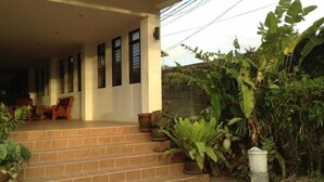 A house with a covered porch, steps leading up to it, and potted plants. - Kamala Phuyai Resort (Kamala)