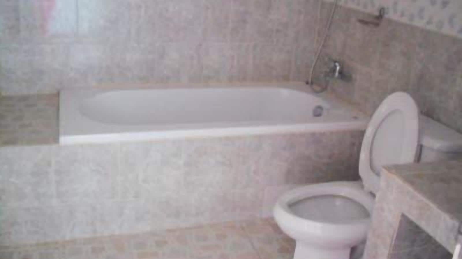 Casa de banho com banheira, sanita e lavatório.