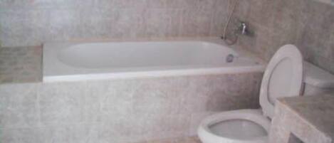 Un baño con bañera, inodoro y lavabo.