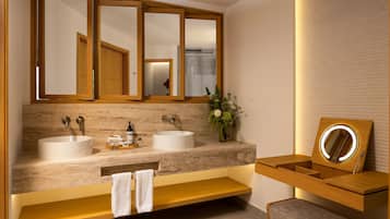 A modern bathroom with two sinks, a vanity with a mirror, and a towel rack.