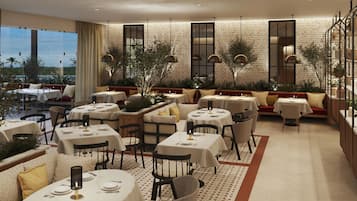 Een restaurant met ronde tafels, comfortabele zitmogelijkheden en uitzicht op de omgeving.