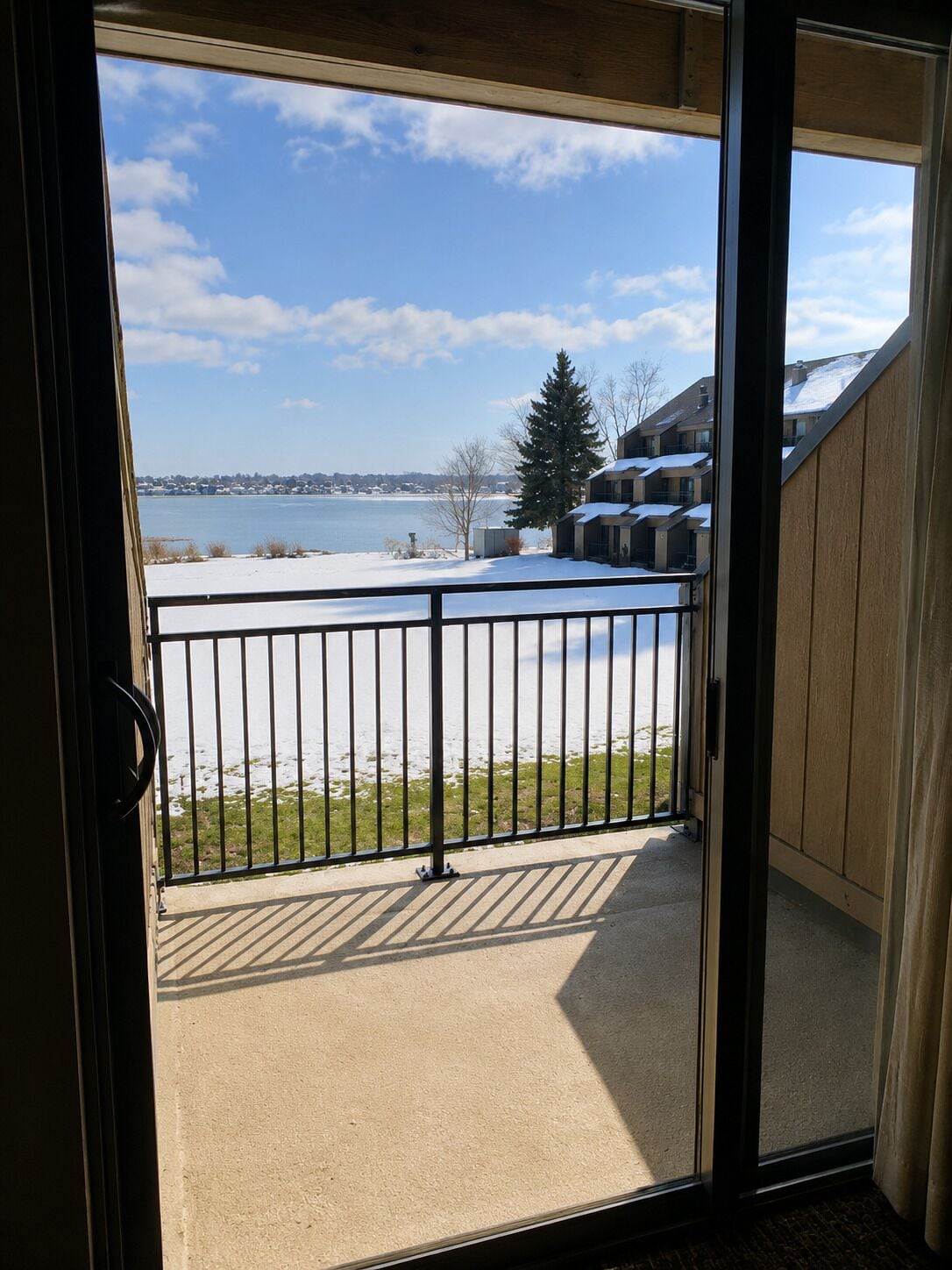 A balcony with a view of a lake and buildings.