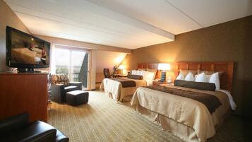 A hotel room with two beds, a TV, a desk, and a chair.
