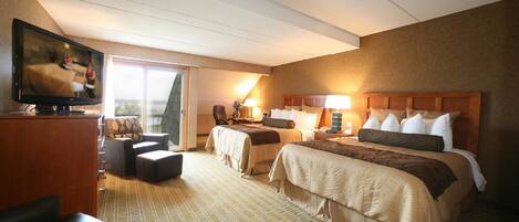 Habitación de hotel con dos camas, televisión, escritorio y silla.