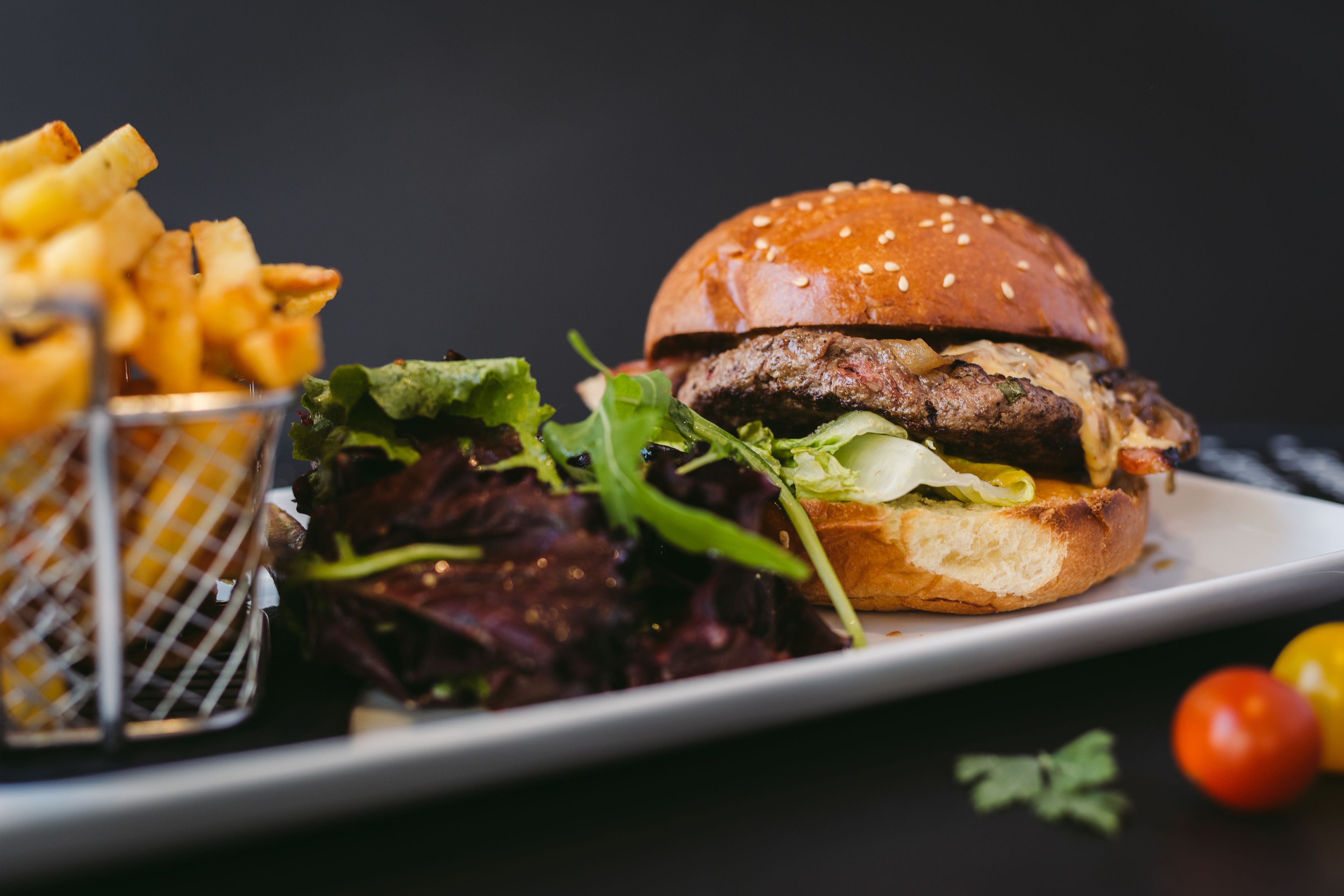 A plate with a burger, fries, and a small salad.