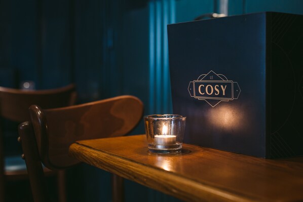 Eine dunkelblaue Schachtel mit dem Logo "COSY" auf einem Holztisch.
