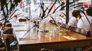 Un restaurante con una larga mesa de madera dispuesta para comer, rodeada de sillas.