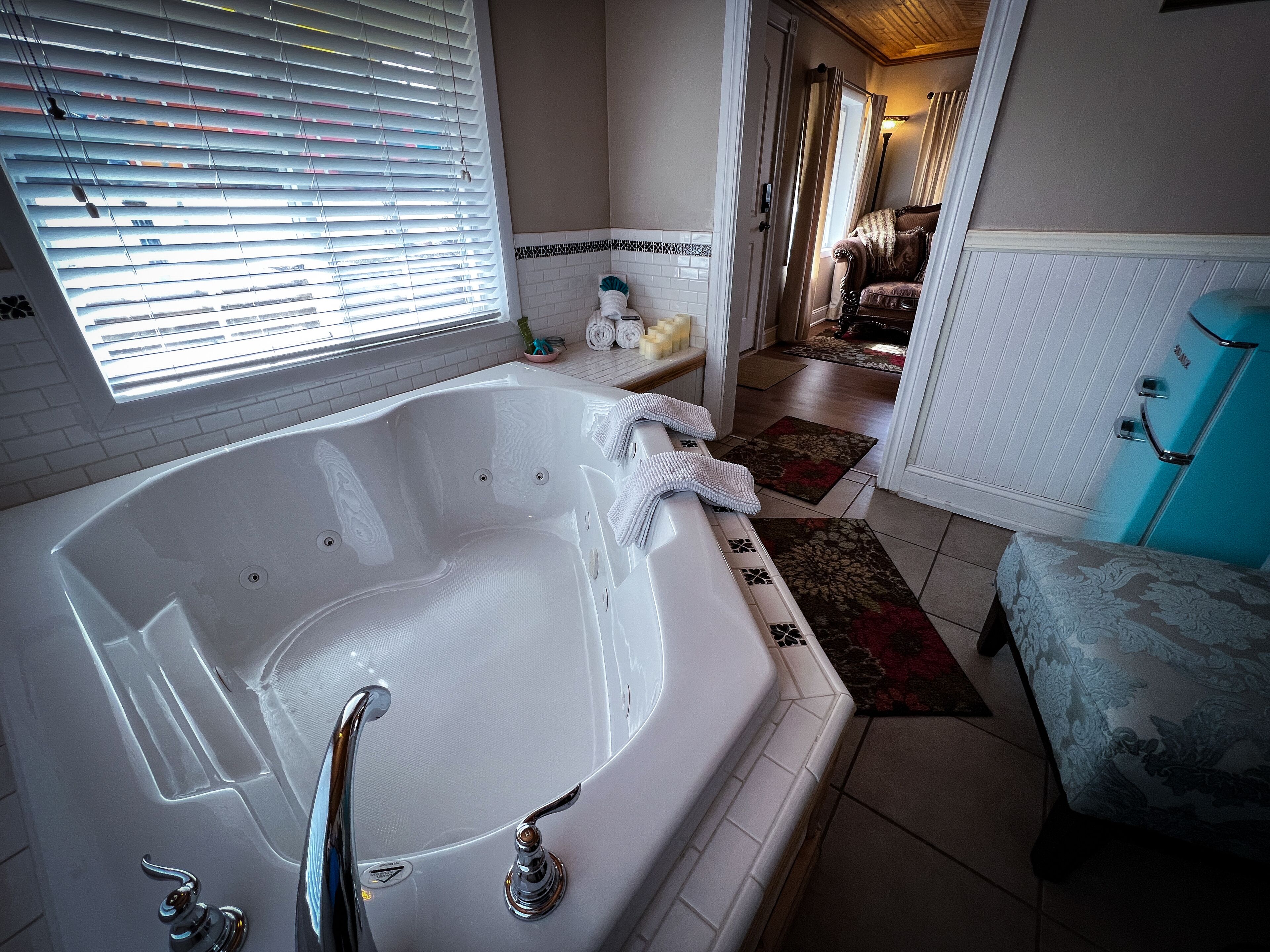 A bathroom with a large bathtub, a shower area, and a vanity with a mirror.