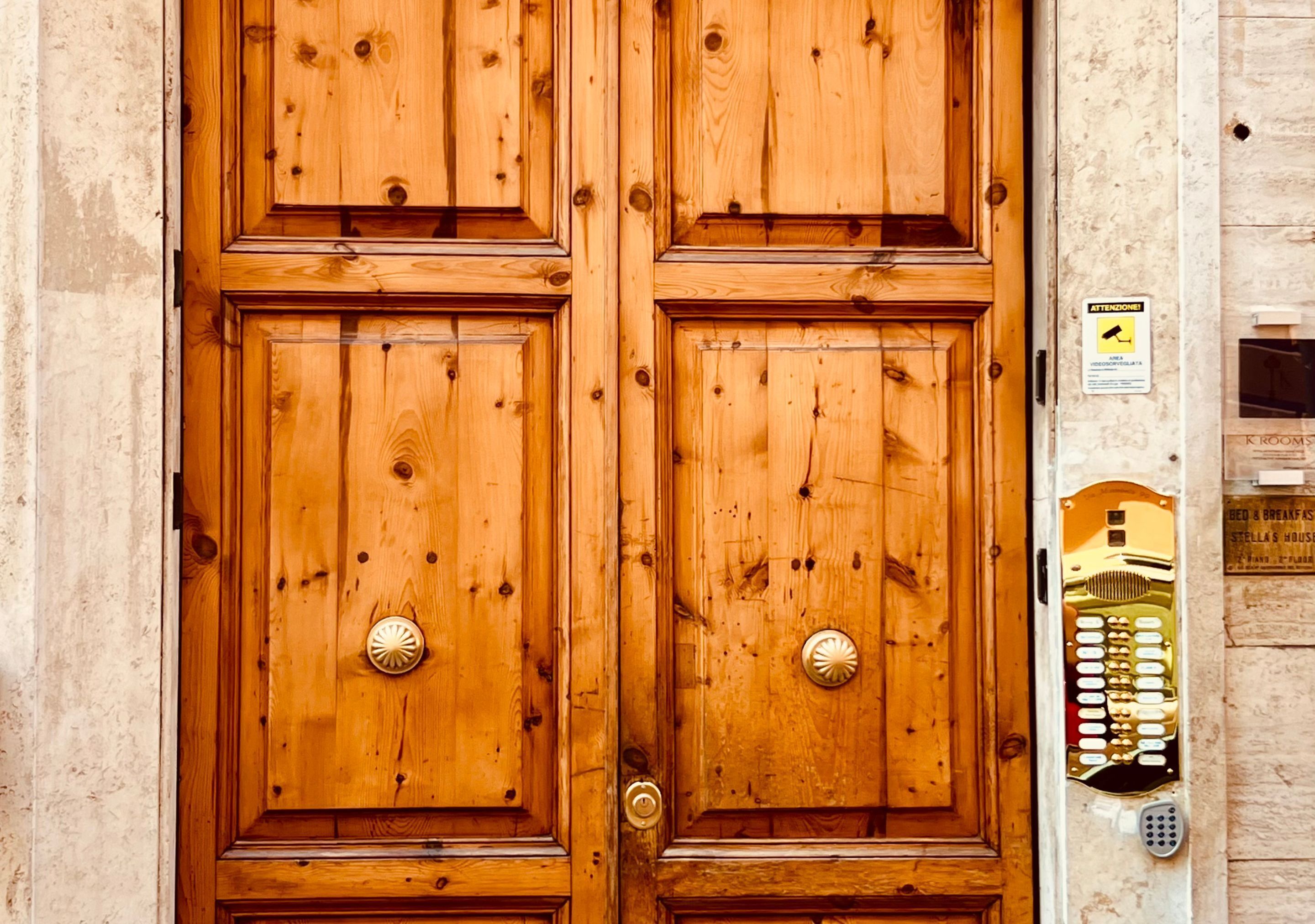 A wooden double door with a keypad lock on the right side.