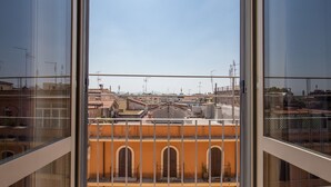 A view from a high-rise window overlooking a cityscape with distinct architectural styles and clear skies. - Bon Ton Design Rooms by DOT Suites (Rome)