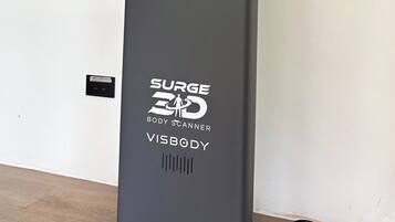 A SURGE 3D body scanner with a VISBODY logo, placed on a stand.