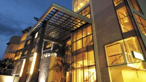 Un hôtel moderne doté d’une entrée imposante, de grandes fenêtres et d’une galerie couverte.