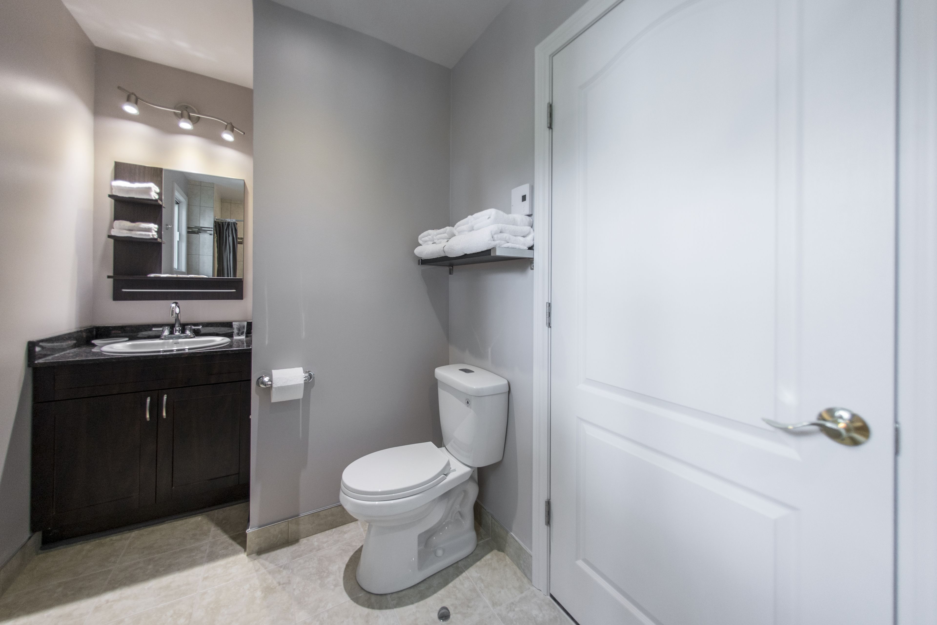 Une salle de bain moderne équipée de toilettes, d’un lavabo et d’un porte-serviettes.