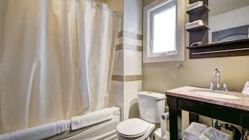 A bathroom with a bathtub, toilet, and sink.