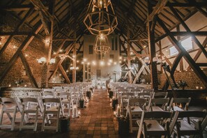 An indoor venue with a high ceiling, wooden beams, and rows of white chairs arranged for an event. - Hotel Winselerhof by Flow (Landgraaf)