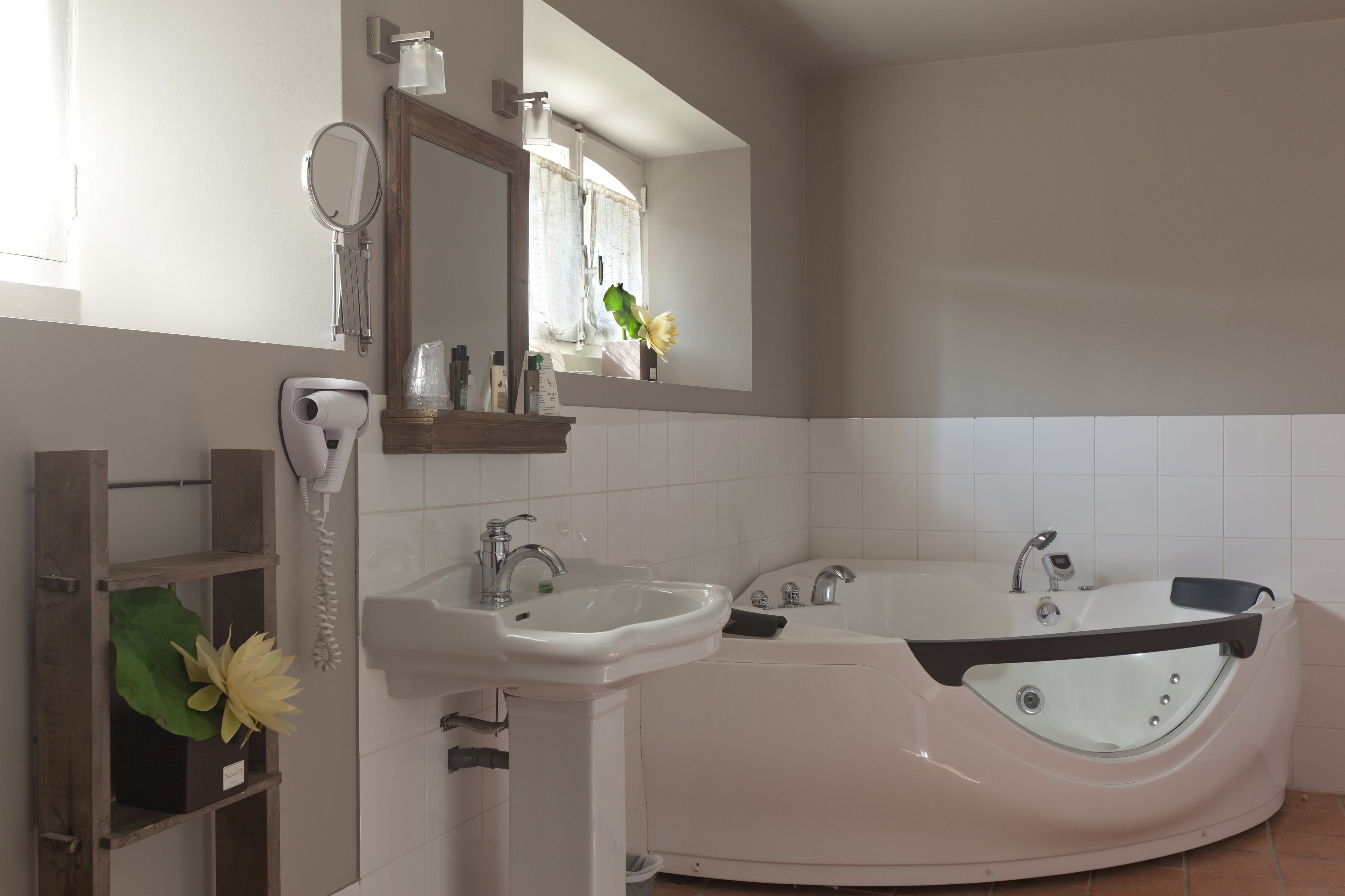 Un baño con lavamanos, espejo y bañera.