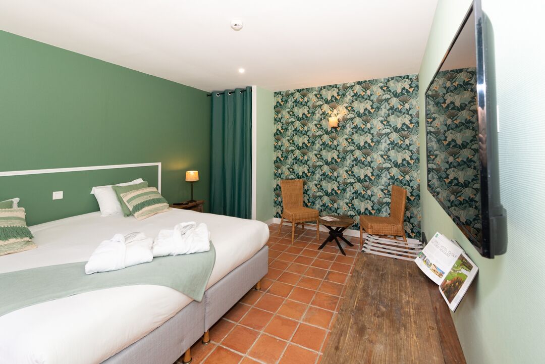 Una habitación de hotel con dos camas, un televisor, una mesita y una silla.