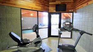 Un gimnasio con bicicleta estática, elíptica y cinta de correr.