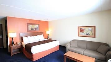 Una habitación de hotel con una cama, un sofá, una mesa de centro y dos lámparas.