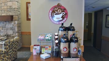 Un espace dédié au café, avec un mur en pierre et le logo d’Americinn Perk.