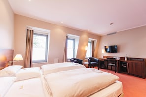 A hotel room with two beds, a desk, a chair, a TV, and a window with curtains. - HOTEL KOCKS am Mühlenberg (Muelheim an der Ruhr)