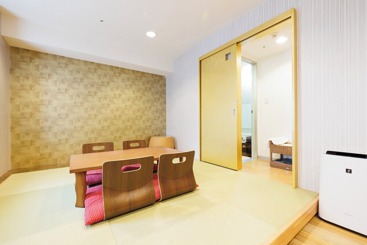 Un'area pranzo moderna con un tavolo e sedie in legno, una parete decorata e una porta scorrevole che dà su un'altra stanza.