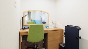 A hotel room with a wooden desk, a green chair, a mirror, a small table with a lamp, a clock, and a suitcase. - Holiday Inn Ana Sapporo Susukino by IHG (Sapporo)
