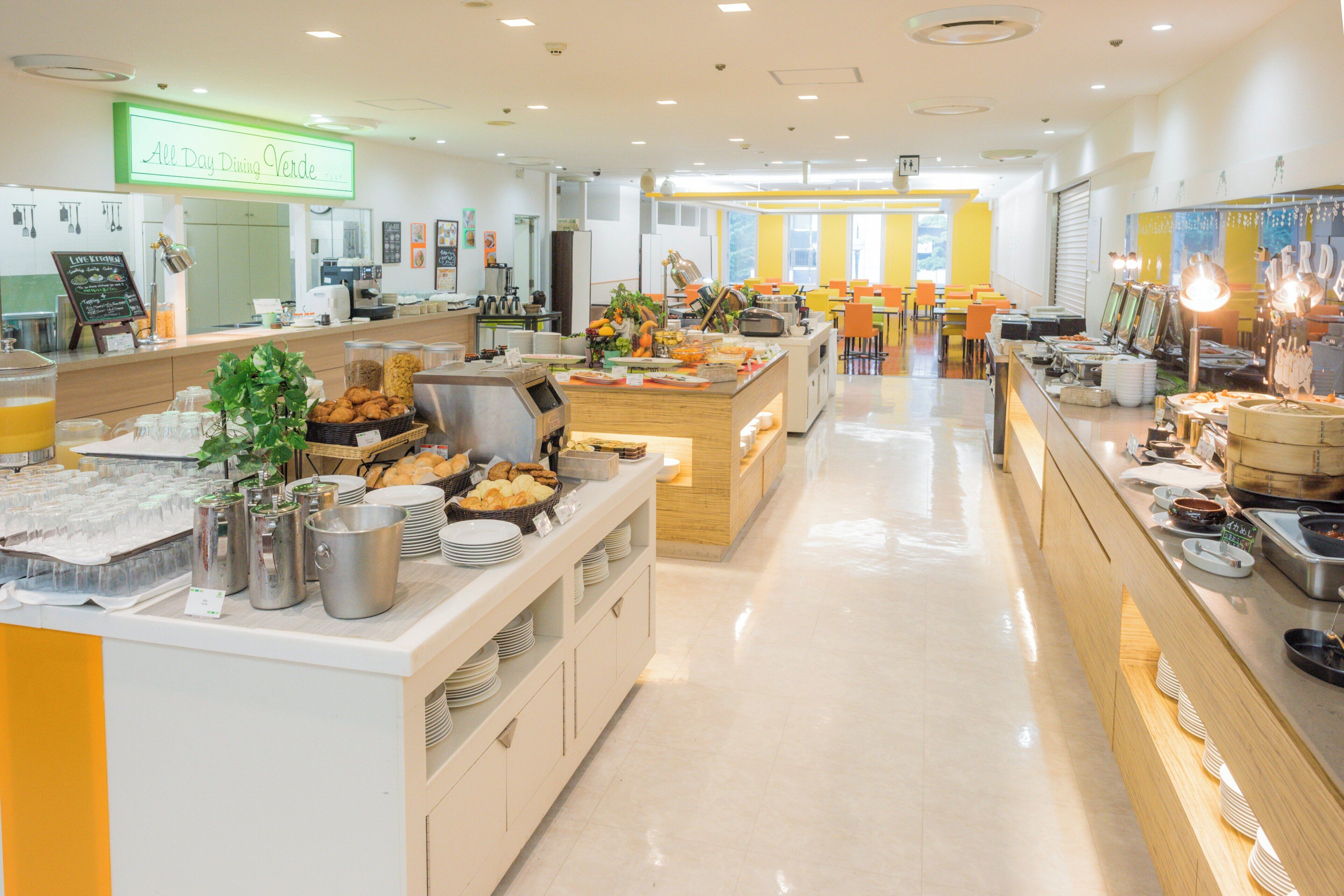Una amplia cafetería con varios mostradores de servicio, una variedad de alimentos y un interior moderno y cuidado.