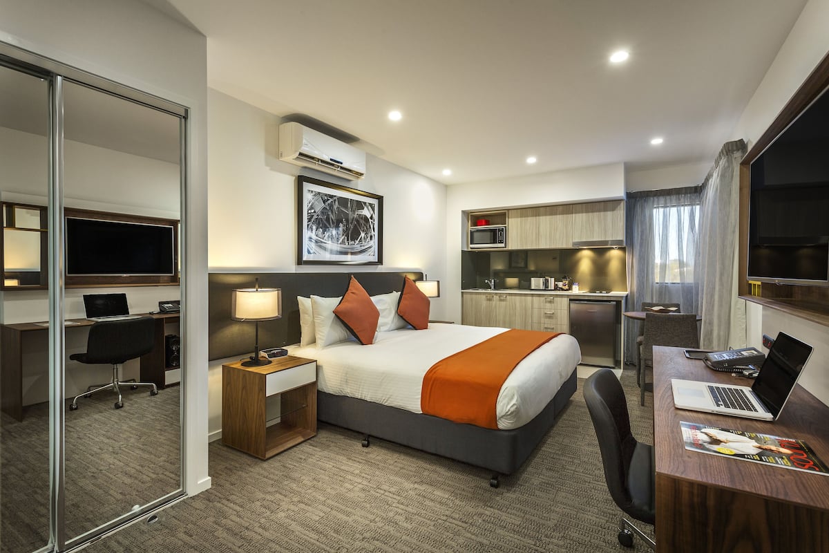 Une chambre d’hôtel équipée d’un lit, d’un bureau et d’une kitchenette.