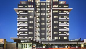A modern hotel with a central tower, multiple balconies, and a ground-level restaurant named "QUEST". - Quest Woolloongabba (Woolloongabba)