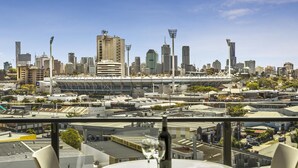 A city skyline with modern buildings and a stadium. - Quest Woolloongabba (Woolloongabba)