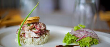 Een bord met een zeevruchtengerecht en een salade.