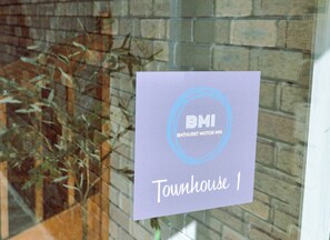 A sign with "BATHURST MOTOR INN" and "Townhouse 1" indicating a specific room or location within the inn.