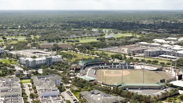 Vista aérea de un estadio con un campo de béisbol, rodeado de edificios residenciales y zonas verdes.
