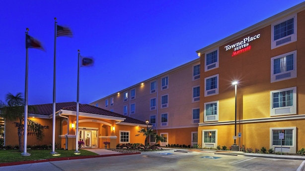 A TownePlace Suites Marriott hotel with a well-lit entrance, multiple floors, and a parking lot.
