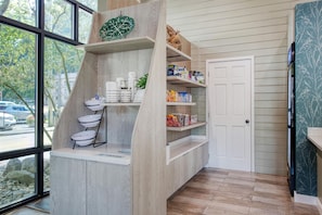 A kitchen with a built-in island, wooden shelves, and a view of the street through large windows. - Best Western Johnson's Inn Downtown Gatlinburg (Gatlinburg)