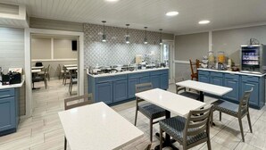 A modern kitchen with blue cabinets, a central island, and a dining area with chairs and tables. - Best Western Johnson's Inn Downtown Gatlinburg (Gatlinburg)