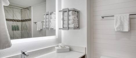 Une salle de bain moderne avec un grand miroir, un lavabo, des toilettes et un porte-serviettes.