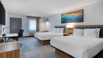 A hotel room with two beds, a desk, a chair, a TV, and a painting on the wall.