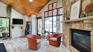 Un interior acogedor con chimenea, paredes de piedra y techo de madera.